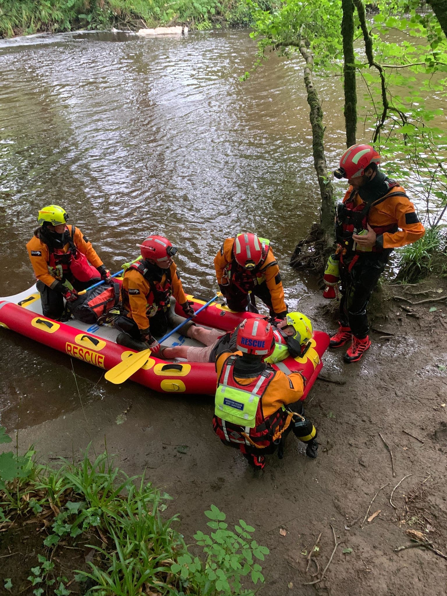 Rescue team moving a casualty by boat