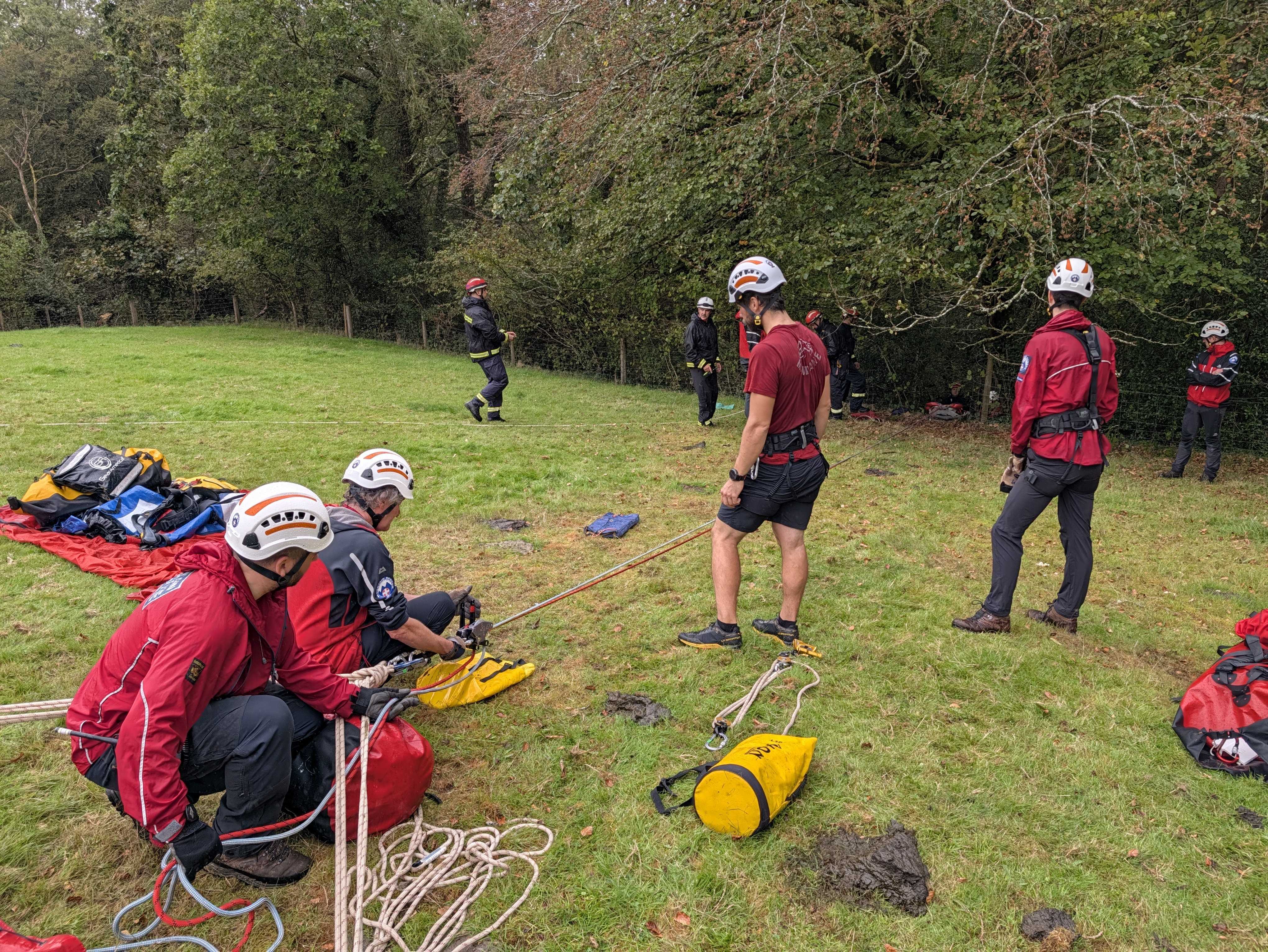 Ropes team members lower the stretcher with two guides down to the casualty